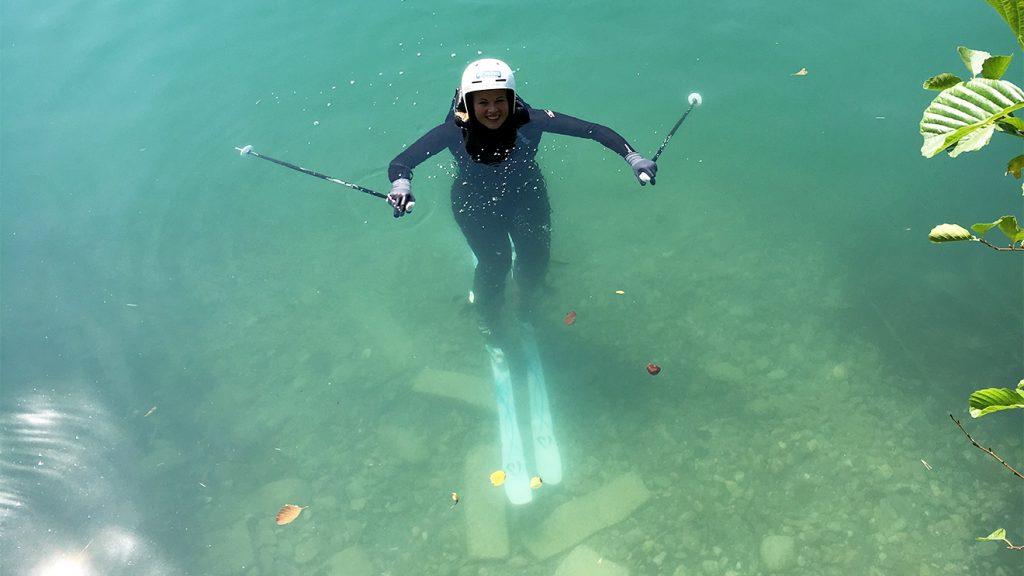 Mit Ski und Stöcken schwimmt Melanie Meilinger ans Ufer © Skiing Penguin